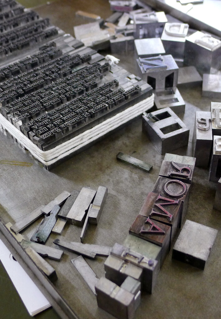 Wooden and lead type being set in a block before printing.